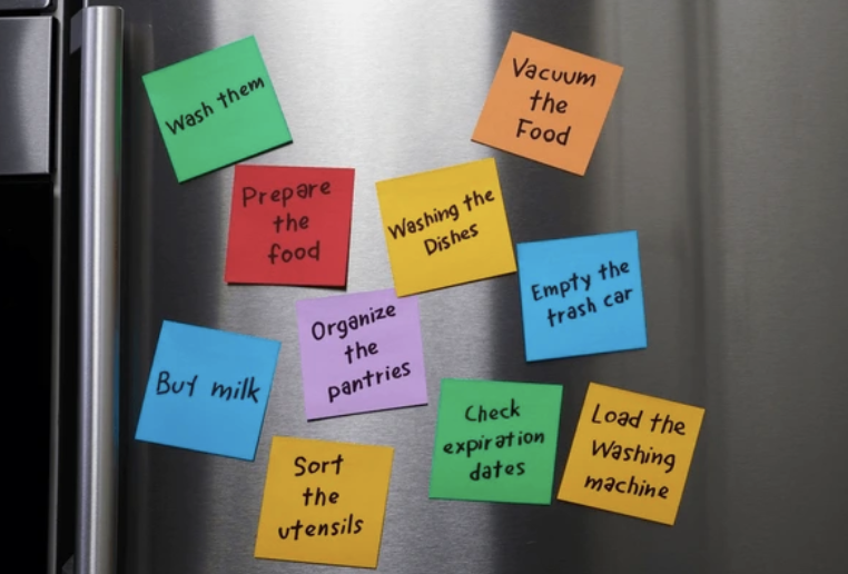 A refrigerator door covered in handwritten sticky notes listing tasks and reminders.