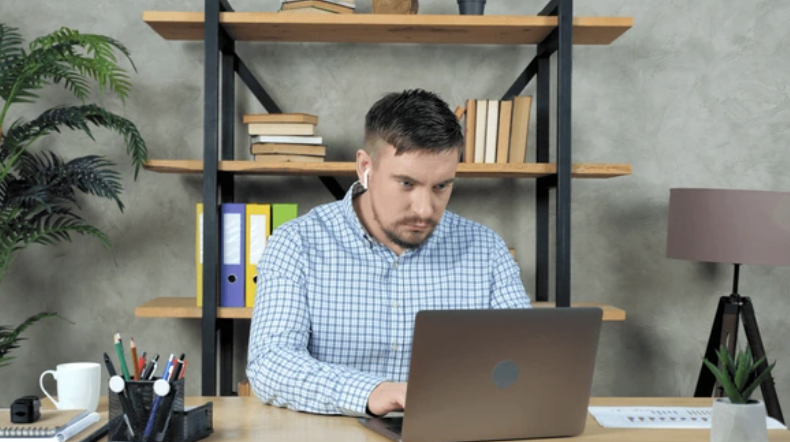 A coach at a home desk during a video call with a client, illustrating the virtual, self-employed structure of most ADHD coaching practices.
