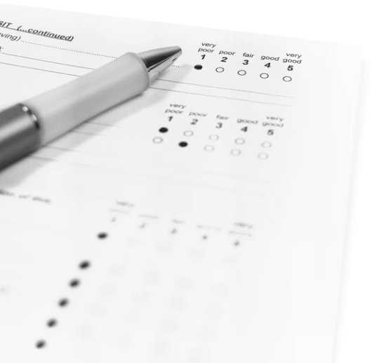 A blank paper rating scale on a desk with a pen resting on it.